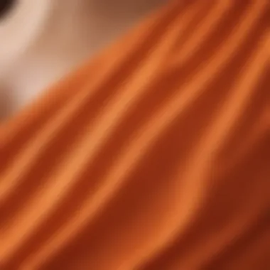 Close-up of the fabric texture of an orange one shoulder swimsuit